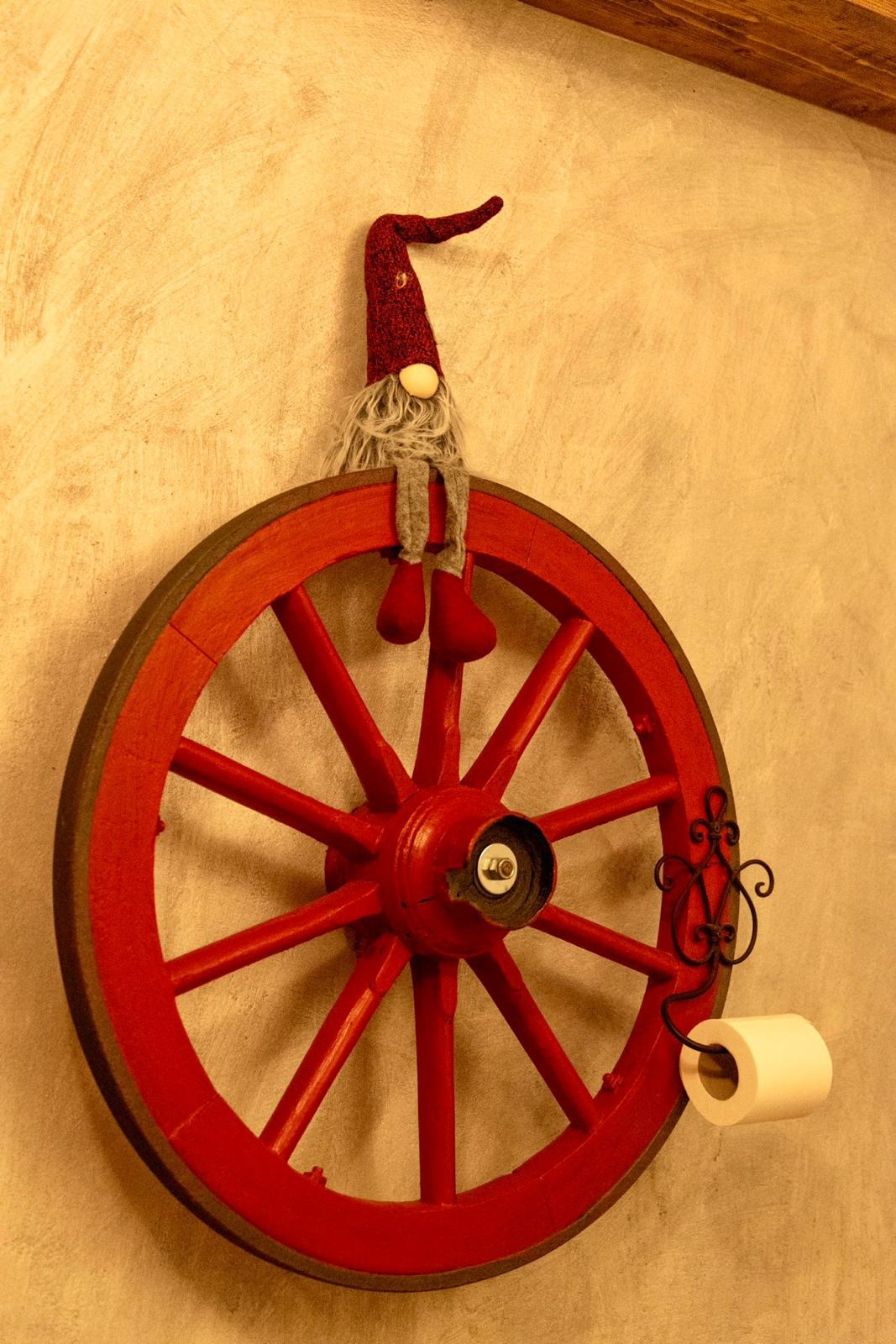 Ruota di carro rossa decorativa con gnomo appesa alla parete
