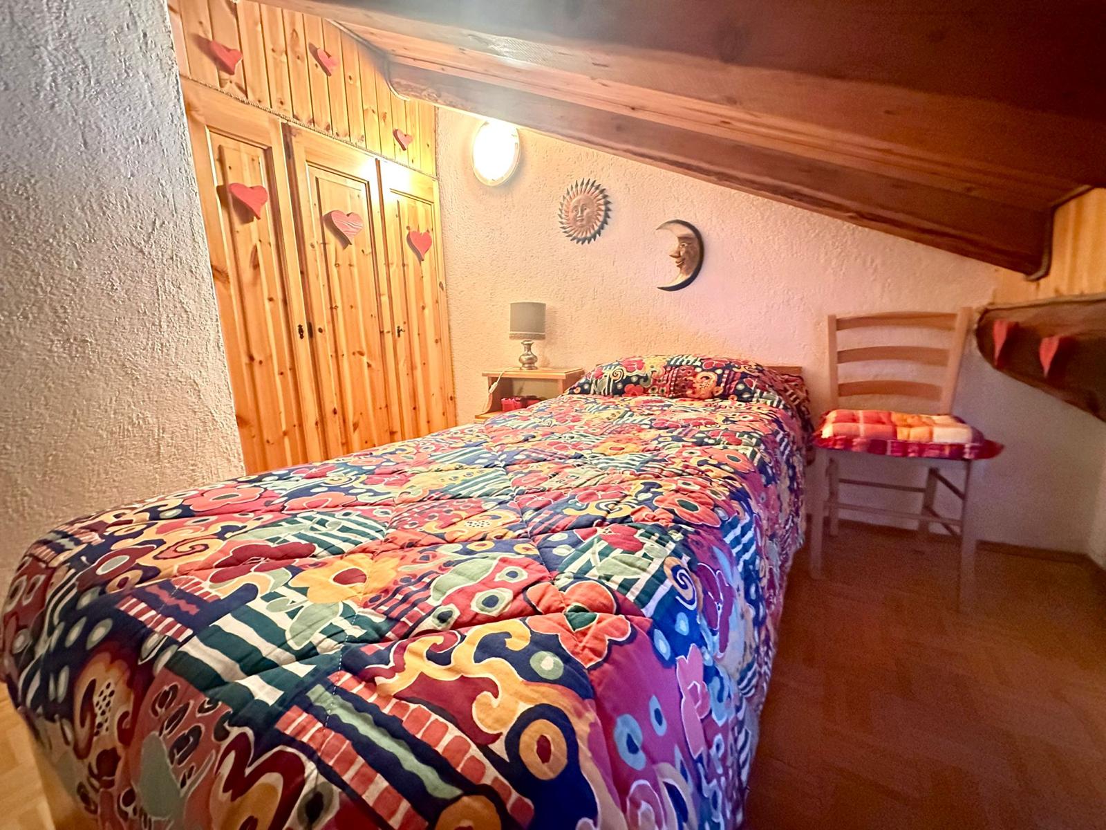 Camera con armadio in legno e copriletto colorato