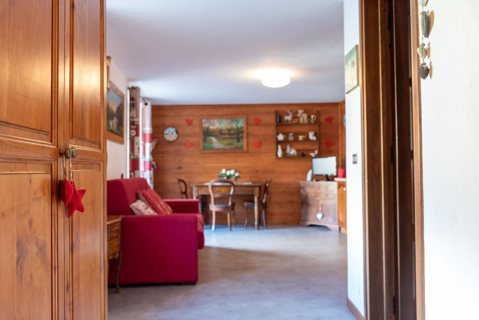 Ingresso dell'appartamento con vista sul soggiorno e divano rosso