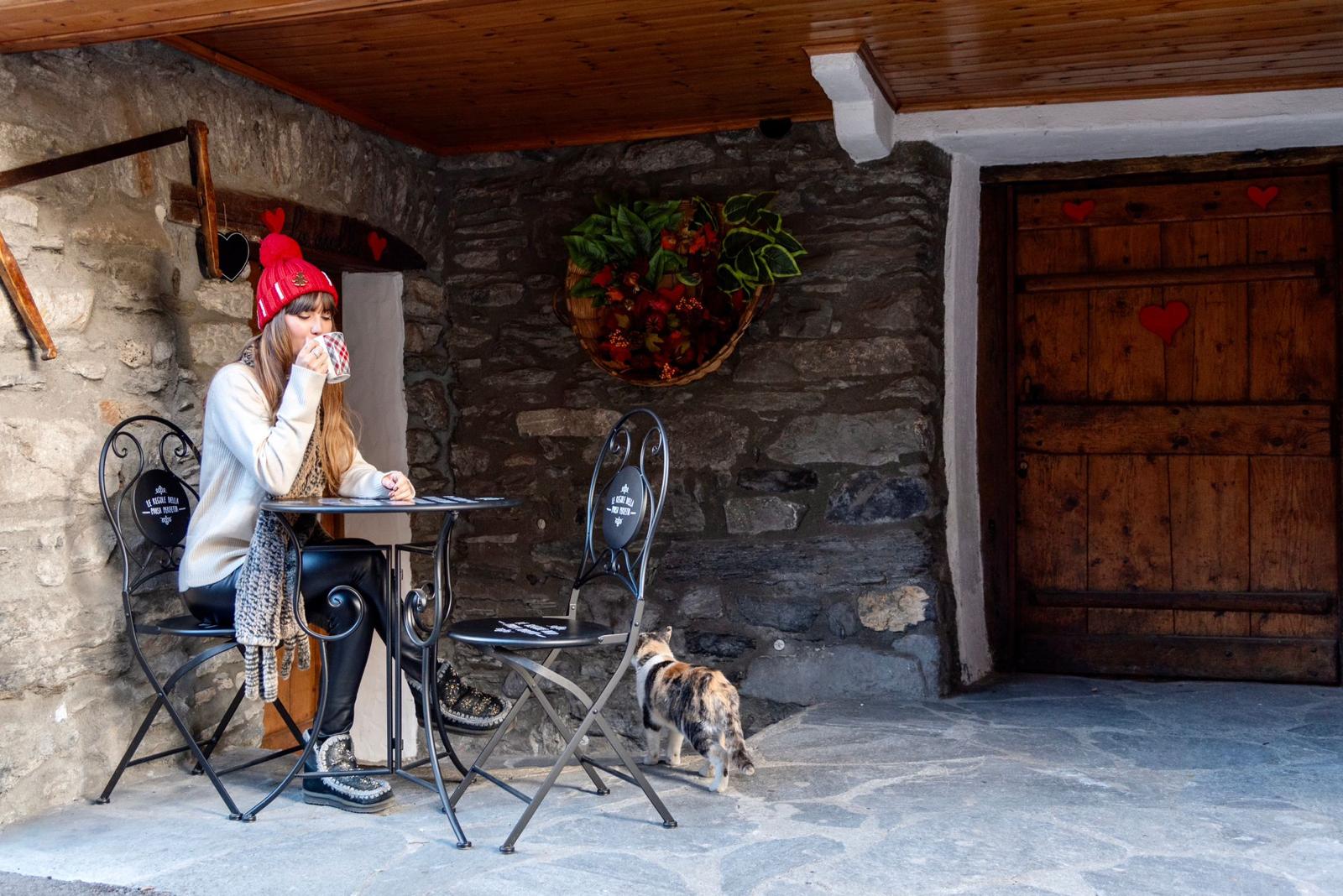 Cortile in pietra con tavolino, colazione all'aperto e gatto di casa