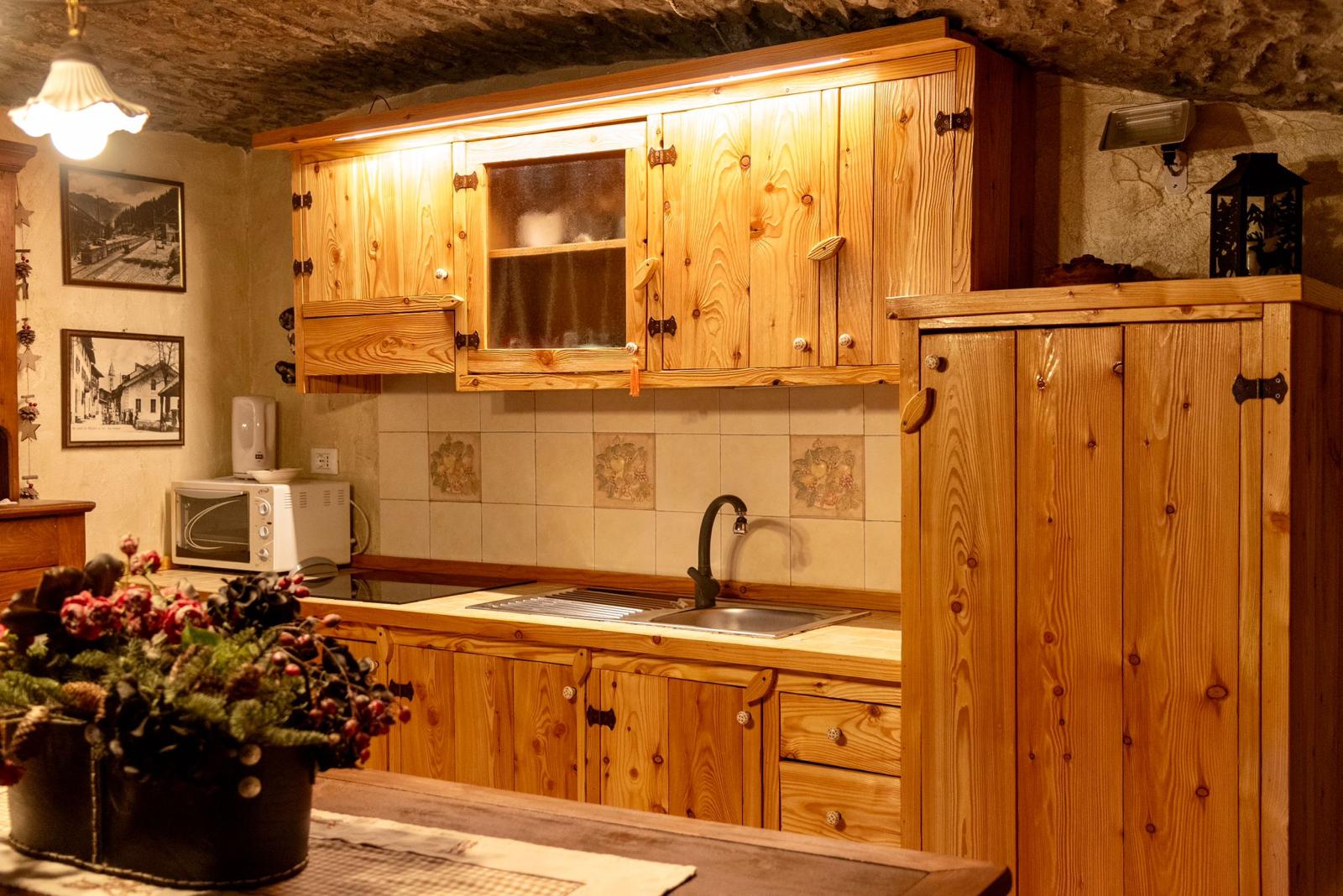 Cucina in legno di larice sotto la volta in pietra