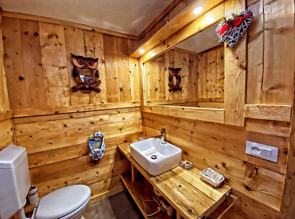 Bagno in legno con specchio a forma di gufo e lavabo bianco